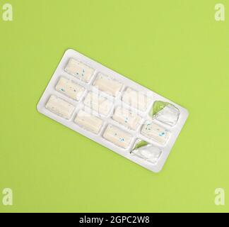 rectangular pieces of gum in a blister pack on a green background, close up Stock Photo