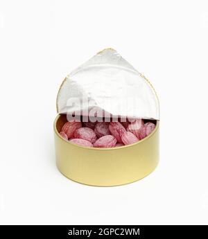 fruit oval lollipops in an open round tin can on a white background, close up Stock Photo
