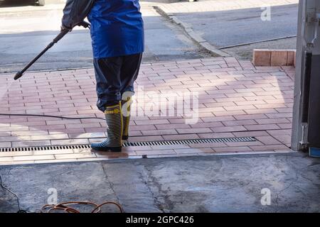 Patio Pressure Cleaning. Caucasian Woman Washing His Concrete Floor Patio Using High Pressured Water Cleaner. Stock Photo