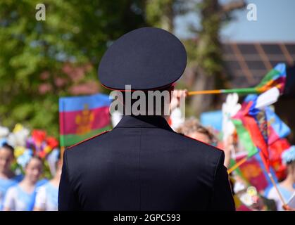 Slavyansk-on-Kuban, Russia - May 1, 2018: A policeman, who cries out the tranquility of citizens at a festive procession. Celebrating the first of May Stock Photo