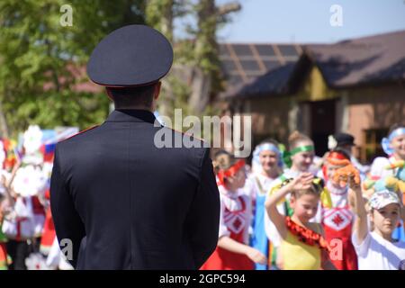 Slavyansk-on-Kuban, Russia - May 1, 2018: A policeman, who cries out the tranquility of citizens at a festive procession. Celebrating the first of May Stock Photo