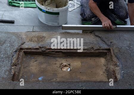 Laying ceramic floor tiles - man hands closeup Stock Photo