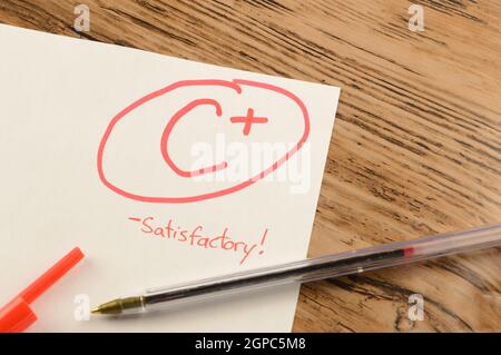 A graded school paper marked in red ink over a wood desktop. Stock Photo