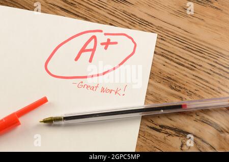 A graded school paper marked in red ink over a wood desktop. Stock Photo