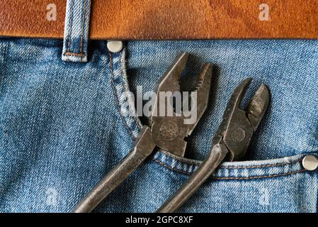 Old pliers in jeans pocket Stock Photo