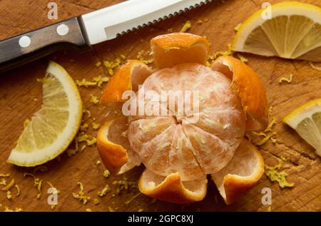 Fresh tangerine fruit and slices lemon on a wooden board, macro, shallow depth of field Stock Photo