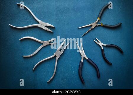 Old used pliers close-up on blue background lying in a semicircle Stock Photo