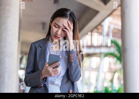 Working woman concept a young businesswoman fatigued after doing a load of work and spending too much time on electronic devices. Stock Photo