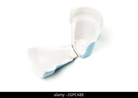 Broken blue teacup isolated on white background. Stock Photo