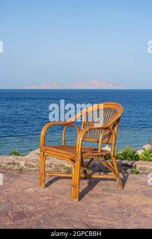 Rattan chair on the tropical beach near the sea in Sharm El Sheikh, Egypt. Travel and nature concept Stock Photo