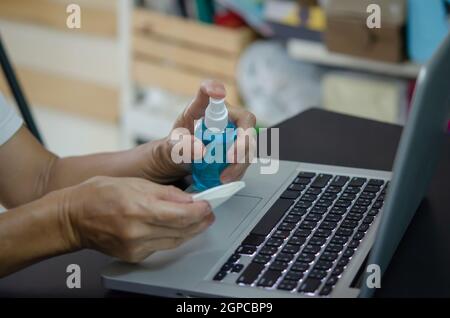 Computer Hygiene Germs Spraying alcohol to clean the computer and wipe the germs. Health care ...
