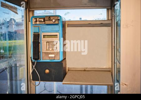 Telephone from an old telephone booth installed in a city Stock Photo