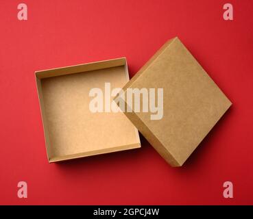 empty square brown box on a red background, gift open, top view Stock Photo
