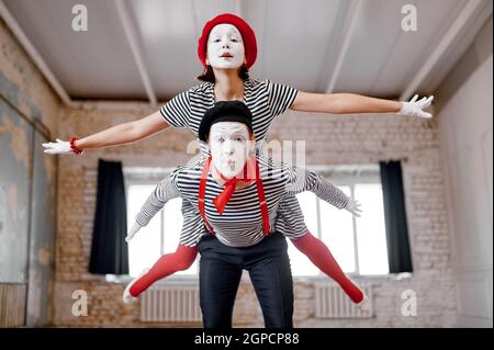 Two mime artists, airplane parody scene, comedy. Pantomime theater, comedian, positive emotion, humour performance, funny face mimic and grimace Stock Photo