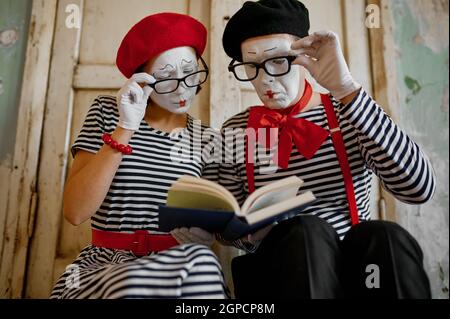 Two clowns in glasses, mime artists, parody comedy. Pantomime theater, comedian, positive emotion, humour performance, funny face mimic and grimace Stock Photo