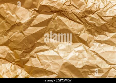 Abstract background texture golden shiny creased foil metal sheet. Stock Photo