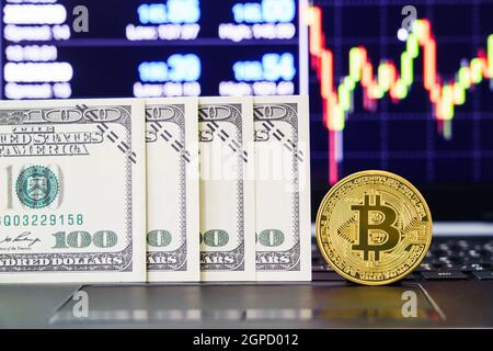 Banknotes and Bitcoins coin on keyboard computer. Close up of  bitcoin crypto currency coins with trading exchange market price chart in the backgroun Stock Photo