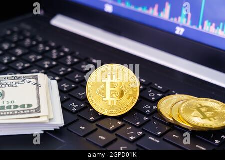 Bitcoins coin and banknotes on keyboard computer. Close up of  bitcoin crypto currency coins with trading exchange market price chart in the backgroun Stock Photo