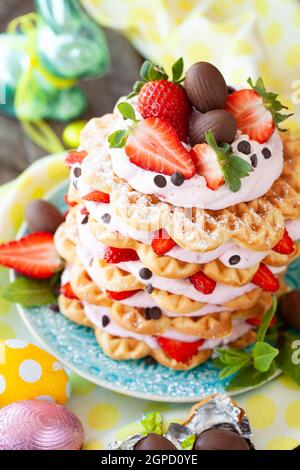 Waffles stacked with whipped cream and fresh strawberries Stock Photo
