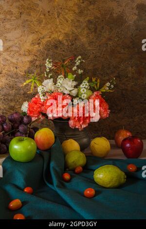 Still life with Fruits were placed together with a vase of flowers beautifully. Stock Photo