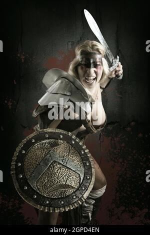 Gladiator posing isolated in a dark background Stock Photo - Alamy