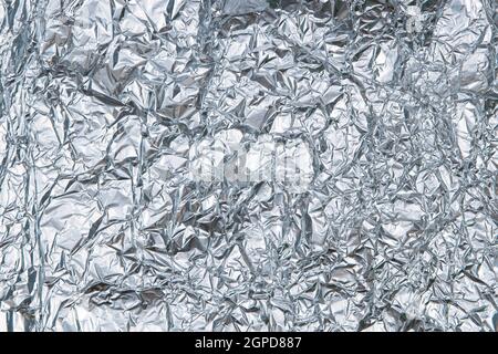 Silver shiny crumpled foil texture background. Top view Stock Photo