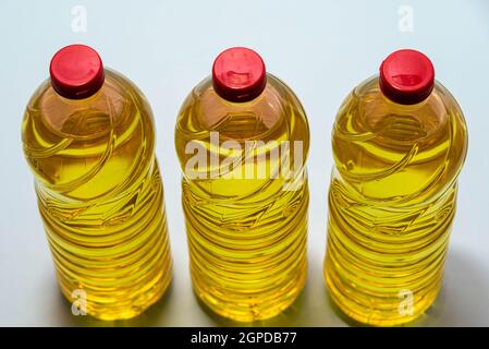 Bottles of edible soy oil on blue background. Olive oil for salads and cooking in general. Soybean oil is extracted from soybean seed and is used as a Stock Photo