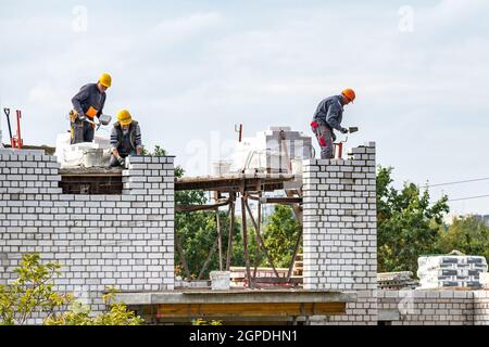 Vilnius, Lithuania - September 28 2021: New buildings or houses under construction with workers at work against cloudy sky Stock Photo