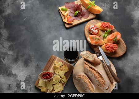 Brushetta or traditional Spanish tapas. Appetizers with Italian antipasti snacks. Variety of small sandwiches with  cherry tomatoes, salmon, cream che Stock Photo