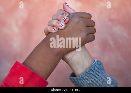 Two children hands of differents races together shaking Stock Photo