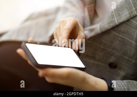 Close-up of a young female entrepreneur relaxing with her smartphone, interacting on social media, browsing the internet, and installing a mobile app. Stock Photo