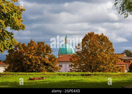 Autumn in Lucca. View of ancient walls public park with autumnal leaves and old dome Stock Photo