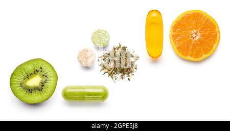 various vitamin supplement pills with citrus fruits on white background Stock Photo