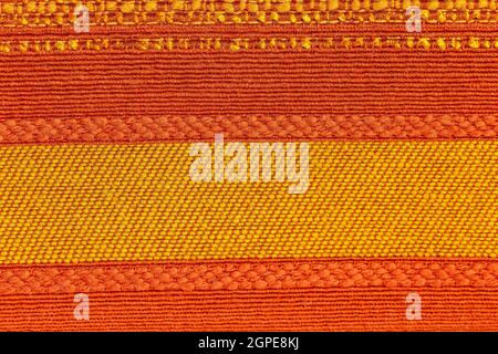 Rustic canvas fabric texture in red, orange and yellow woven color. Stock Photo
