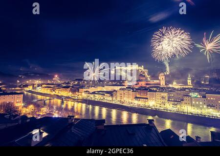 Colorful firework in the night: Old city of Salzburg and Festung Hohensalzburg at New Year’s Eve. Magic Stock Photo