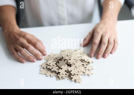 Decomposition of puzzles and female hands on table closeup Stock Photo