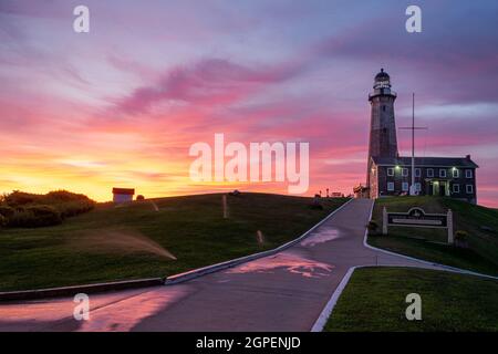 Sunset at the Montauk Point Light is a lighthouse located adjacent to Montauk Point State Park, at the easternmost point of Long Island, in the hamlet Stock Photo