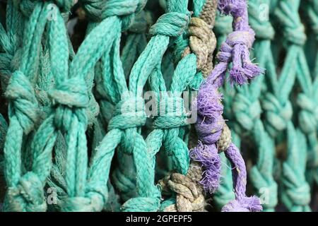 detail of old knotted fishing net of aqua colored nylon rope Stock ...