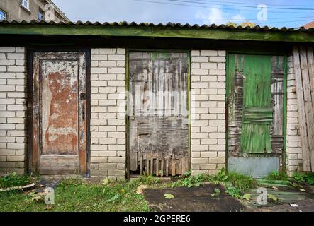 Three very old barn doors made of rough textured hardly weathered old plywood Stock Photo