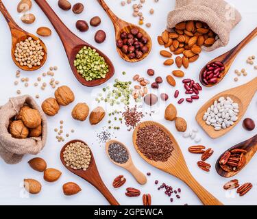 Various legumes and different kinds of nuts in spoons. Walnuts kernels ,hazelnuts, almond ,brown pinto ,soy beans ,flax seeds ,chia ,red kidney beans Stock Photo