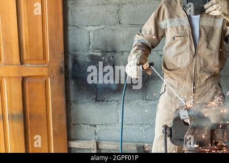 Welder welding in backyard in the morning Stock Photo