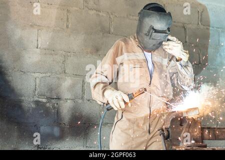 Professional Latin welder working in the garage factory Stock Photo