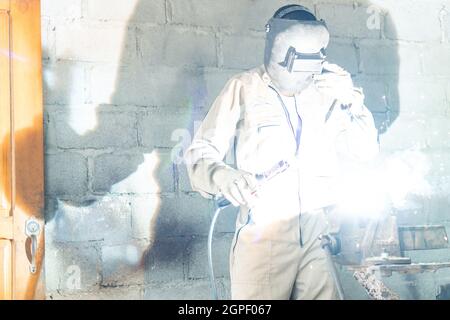 Professional welder working in the garage factory Stock Photo