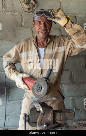 Man standing at his workplace smiling and looking at the camera Stock Photo