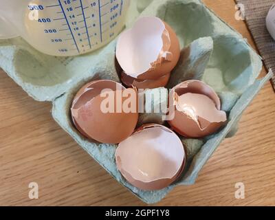 Four broken eggshells in an egg carton packaging having been used as a cooking ingredient and ready to be recycled as food waste Stock Photo