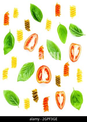 Italian food concept Fusilli pasta with tomato sliced and sweet basil leaves isolate on white background. Pasta and ingredients for foods background a Stock Photo