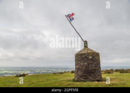 A battered Union Jack flag pictured on top of a Cairn in Garstang, Lancashire in September 2021.  It was originally built for the Golden Jubilee of Qu Stock Photo