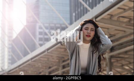 Lay off. Sacked. Fired business woman sitting on stairs of office building outside. Depressed young business woman unemployment due to coronavirus cri Stock Photo
