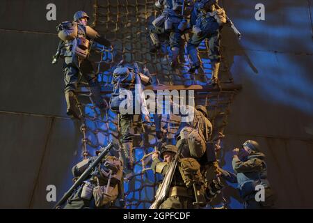 Soldiers climbing down a rope ladder onto a Higgins landing craft transport boat during D-Day in WWII. At the National Museum of the United States Arm Stock Photo