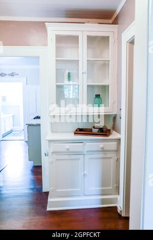 An original white wood bookcase built in with glass doors in a short-term rental house Stock Photo